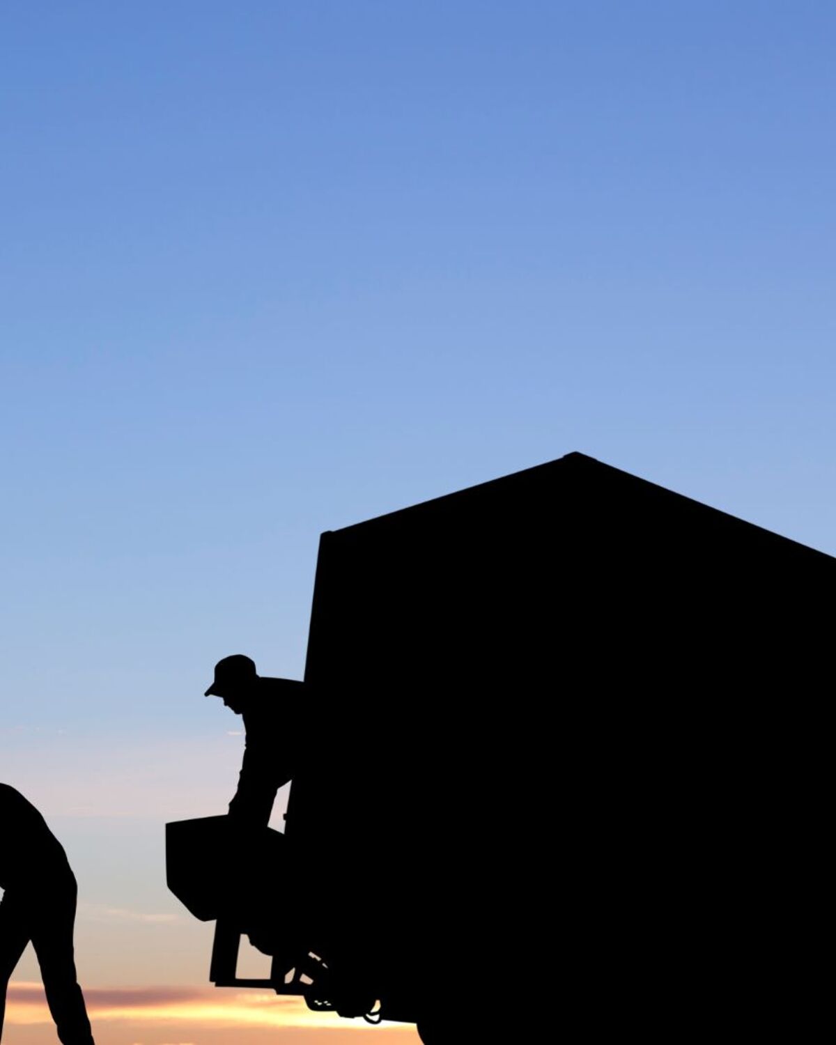 Two Brothers Moving Service crew loading a box truck at dusk in Rutland, VT