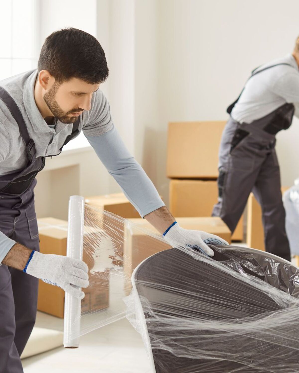Movers shrink-wrapping furniture during a Barre area move