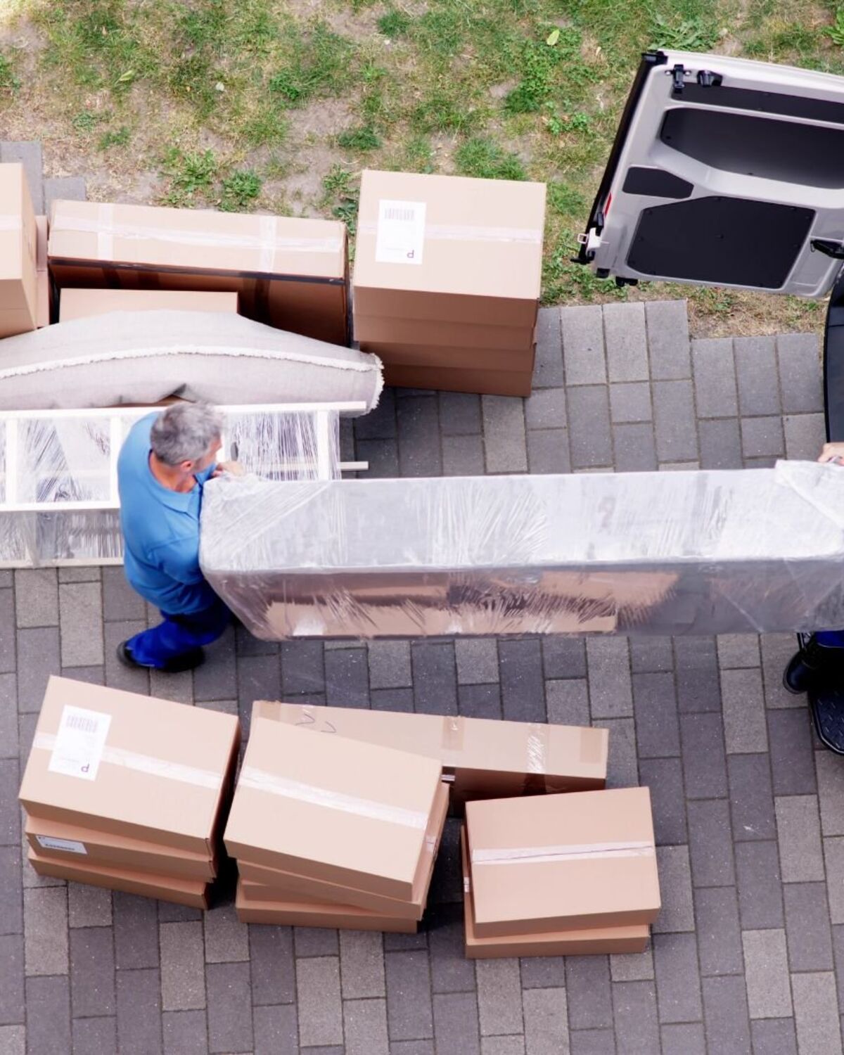 Overhead view of movers loading a mattress and boxes into a van